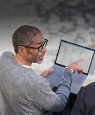 A man pointing his finger at a laptop.