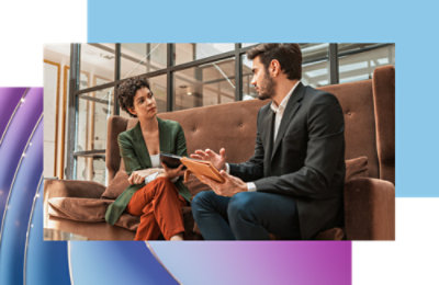 Two people sitting on a couch and discussing.