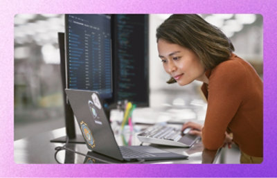 A woman looking at a laptop on a desk