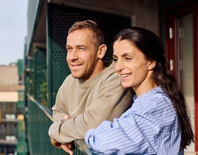 A man and woman leaning on a railing.