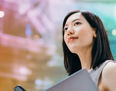 A women is looking holding laptop.