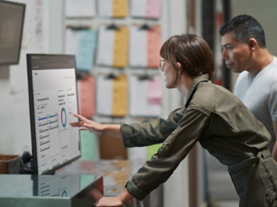 People analyzing dashboard data on large display.