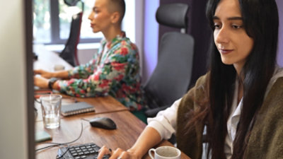 Una mujer sentada en un escritorio con un ordenador.