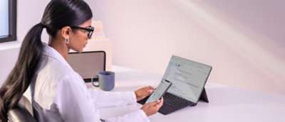 Una mujer sentada en un escritorio utilizando un portátil.