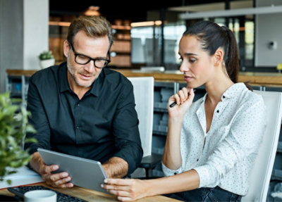 Un homme et une femme regardant une tablette.