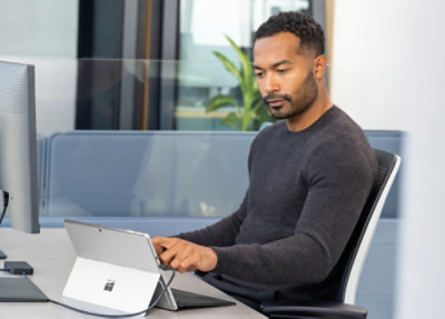 A person sitting at a desk using a device.