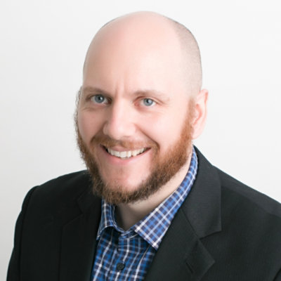 Close-up portrait of a person with a beard in a blazer