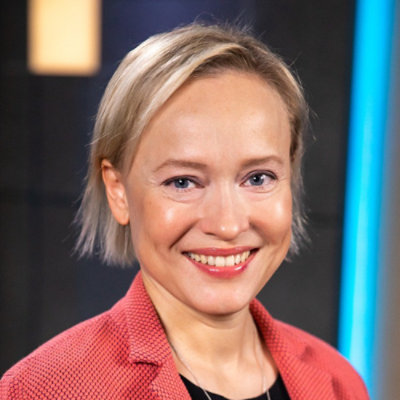 Close-up portrait of a person with short light hair smiling at the camera.