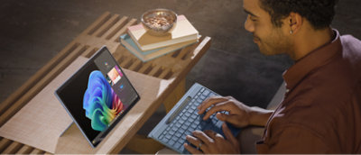 A man reviews the Microsoft Surface Pro X while using it as a laptop.