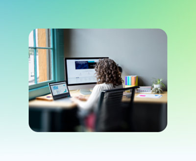 A person sitting at a desk looking at a computer