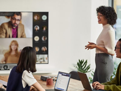 A woman in a white shirt standing in front of a group of people.