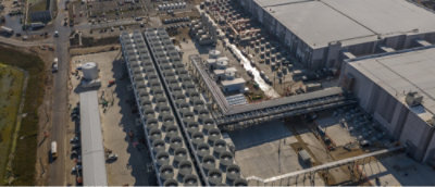 Aerial view of a large industrial facility with rows of cooling units and infrastructure.