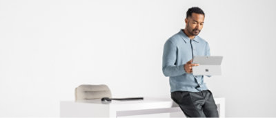 Person using a tablet while seated at a desk.