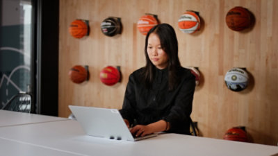 A woman sitting at a table using a laptop.