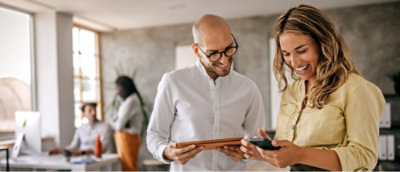 A man and woman looking at a tablet.