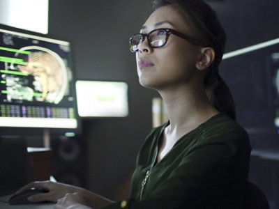 A woman looking up at a computer screen