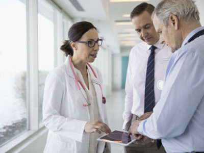 A group of doctors discussing something on a tablet