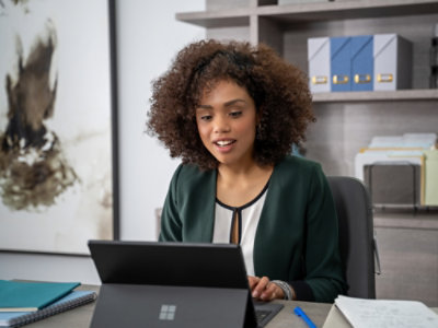 A person sitting at a desk looking at a laptop.