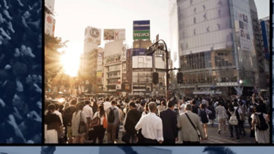 Crowded city crosswalk at sunset