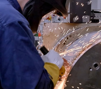 Ein Mann schweißt ein Metallobjekt.