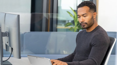 Ein Mann, der auf einer Couch sitzt und einen Laptop benutzt.