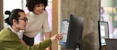  A man pointing to the computer screen, explaining to his colleague