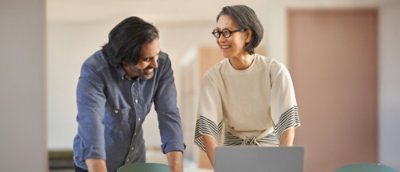 A man and woman looking at a laptop