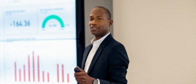 A man in a black suit explaining something