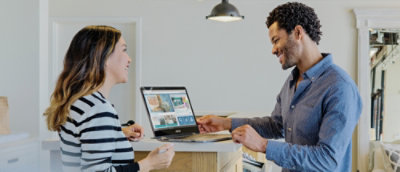 A man and woman looking at a laptop.