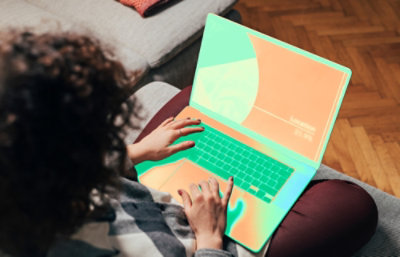 Uma pessoa sentada em um sofá usando um laptop.