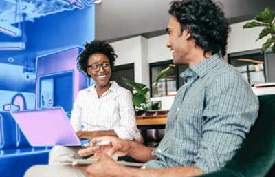 Um homem e uma mulher olhando para um laptop.