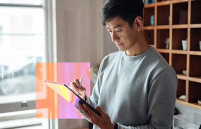 Um homem de camisa cinza usando um tablet.