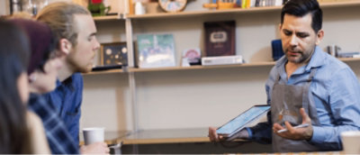 A person sitting at a desk with a tablet.