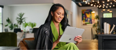 A woman in a green suit holding a tablet.