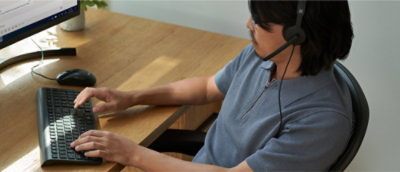 A person with headphones working on a laptop