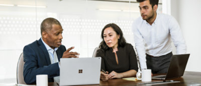 会議室にいる 3 人が、ノート PC を開いて議論をしています