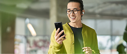 A man holding a cell phone and smiling.