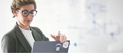 A woman wearing spectacles working on her laptop