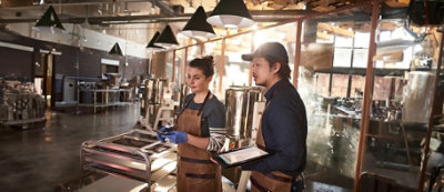 Man and woman in aprons standing in a factory