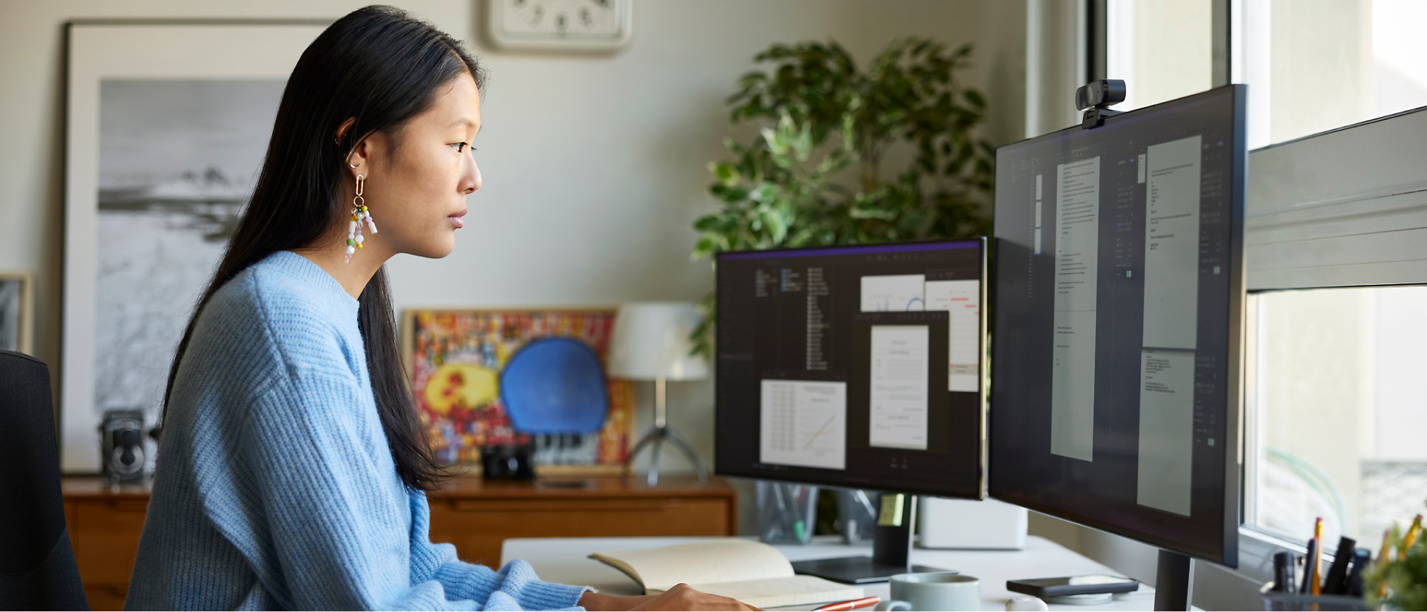Una persona trabaja en el escritorio con varios monitores que muestran documentos y código