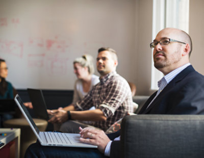 A person sitting at a table with a laptop