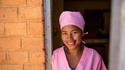 Women in pink scrubs posing in a doorway for a photo.