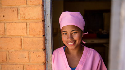 Women in pink scrubs posing in a doorway for a photo.