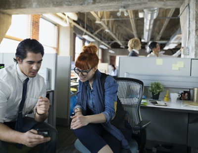 A man and woman sitting in an office.