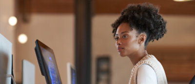 Professional woman working intently at a computer in an office setting.