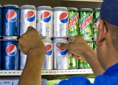 Muž drží plechovku Pepsi.