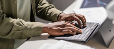 A close-up of hands typing on a keyboard.