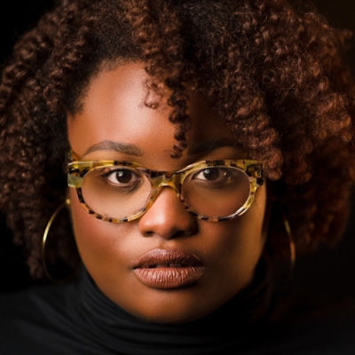 Portrait of a person wearing glasses with curly hair
