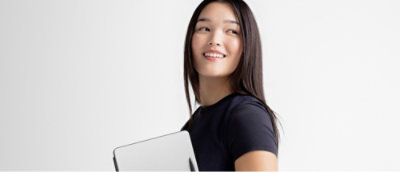 A person holding a clipboard and pen while smiling.