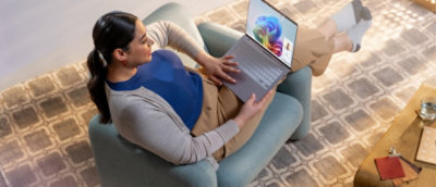 ラウンジ チェアでノート PC を使う人物
